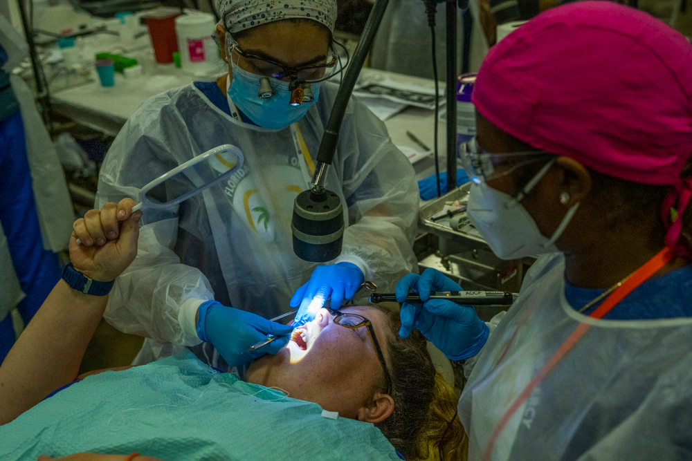 Dental treatment, patient holding mirror to watch